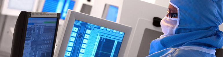 Laboratory worker in front of computer screens.
