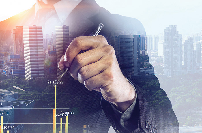 A man writing a graph in front of a skyline.